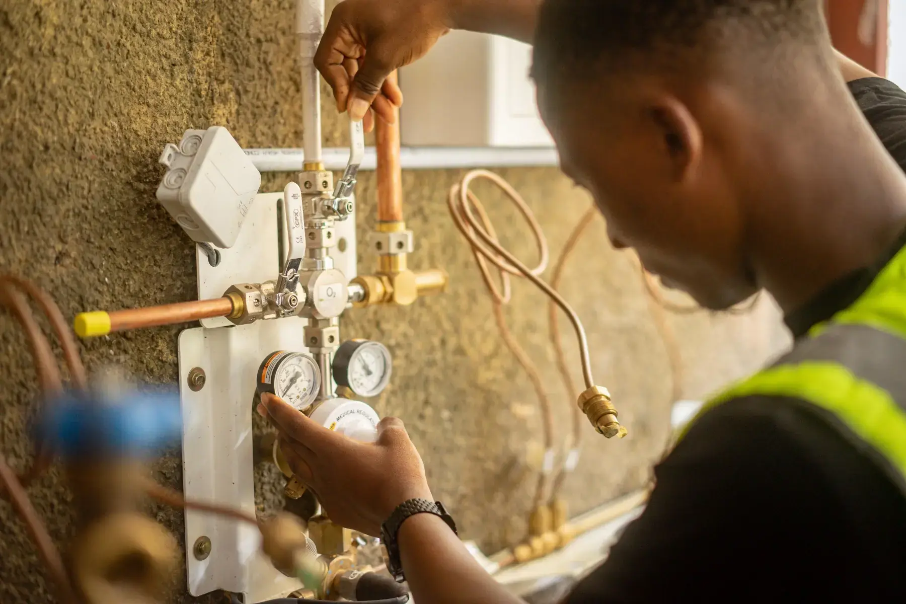 Technician installing a medical regulator on a copper manifold
